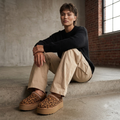Model wearing runway boutique leopard print platform slip-on slippers with beige cargo trousers in a studio setting
