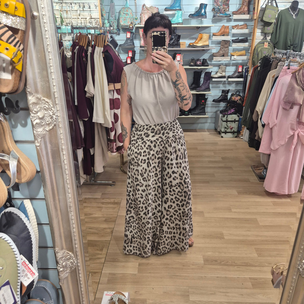 Runway Boutique high waisted wide leg trousers in a leopard animal print, styled with a beige sleeveless top.